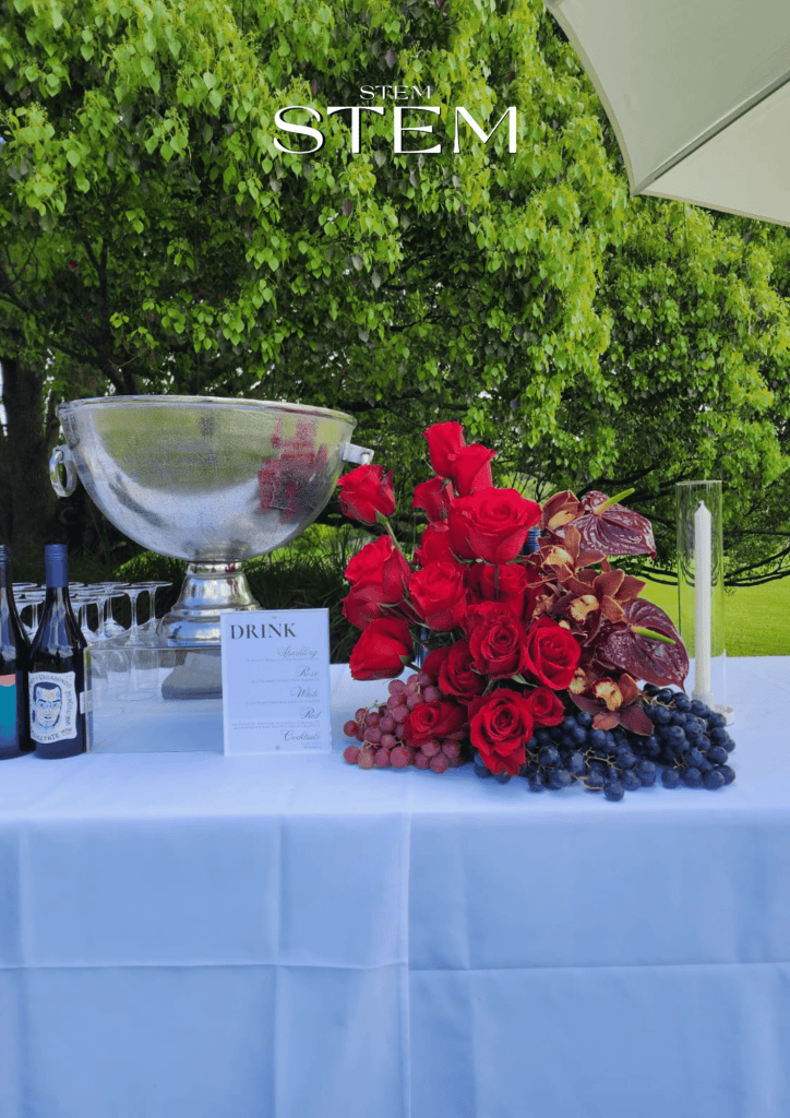 Flower arrangements for cocktail parties – luxury design with red roses, orchids, anthuriums, and grapes styled by Stem Design Brisbane.