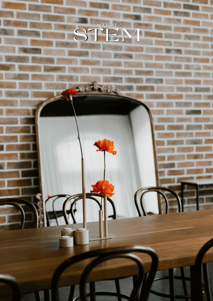 Minimal floral arrangement with red and orange flowers in slim gold vases styled by Stem Design Brisbane.