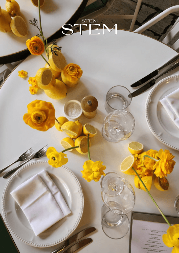 Simple spring table arrangement with bright yellow flowers and lemons styled by Stem Design in Brisbane.