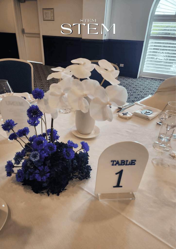 White orchids and blue cornflowers arranged by Stem Design for a christening event in Brisbane.