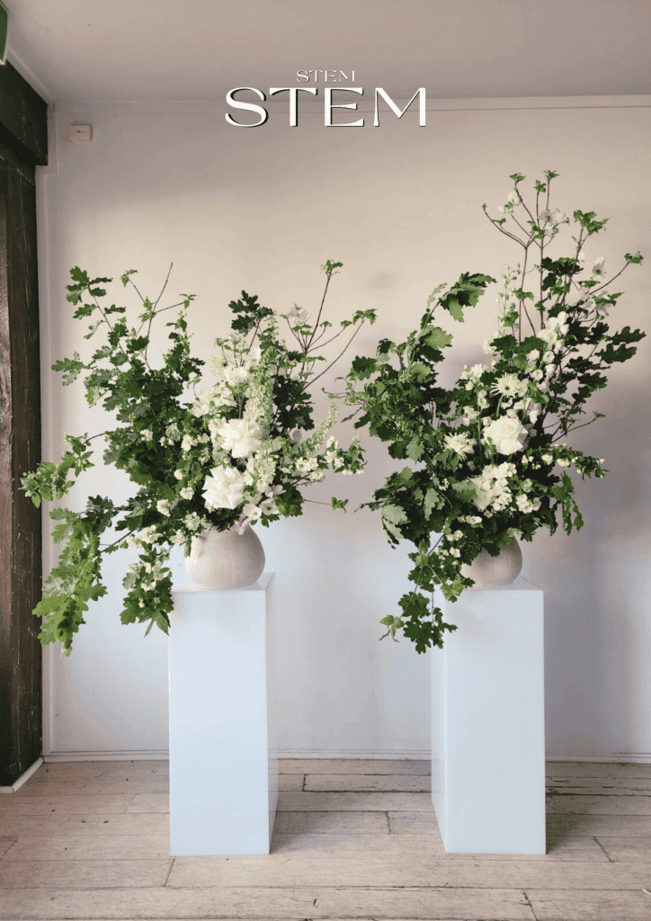 Event florist Brisbane styling a wedding reception with elegant wedding flowers and greenery installations