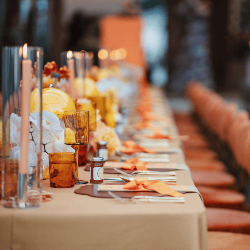 Wedding reception table with warm orange styling and flowers