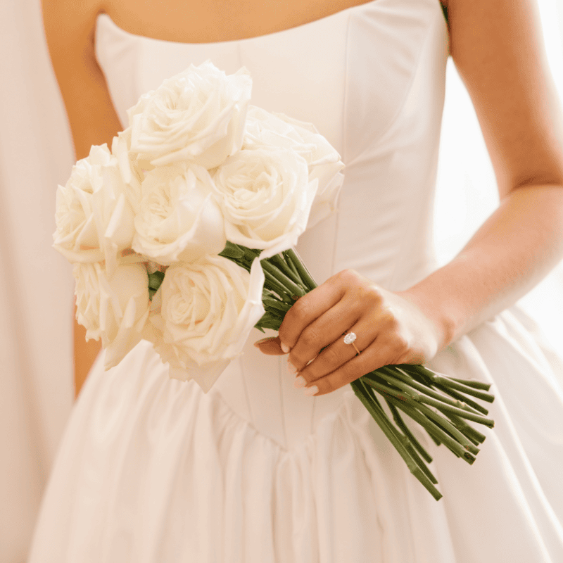 Bride holding classic white rose wedding bouquet